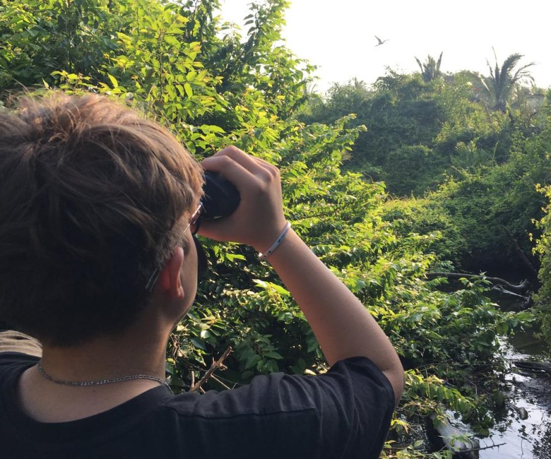 A teenager on a tailor-made volunteer trip for his school participates in a bird survey in Mexico. A high school student on a bespoke group trip with his peers observes birds in Mexico.